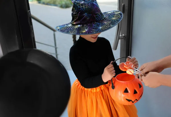 Linda niña vestida como bruja truco o trato en la puerta. Tradición Halloween —  Fotos de Stock