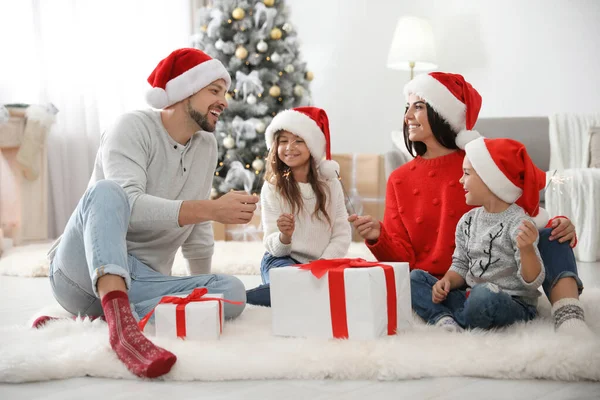 Счастливая семья с детьми и рождественские подарки на полу дома — стоковое фото