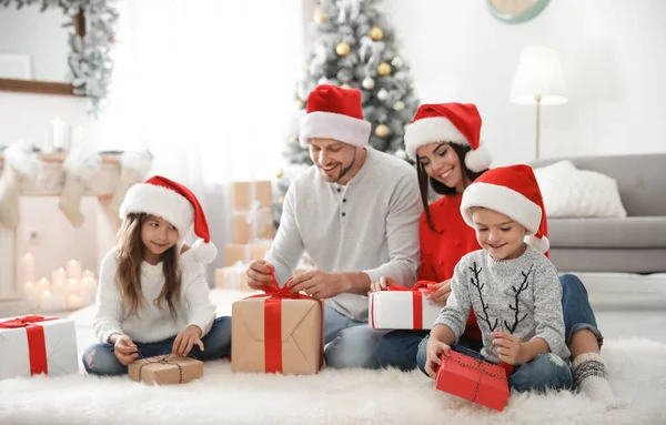 Glad familj med barn och julklappar på golvet hemma — Stockfoto