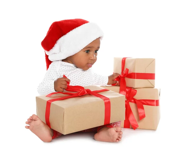 Festively dressed African-American baby with Christmas gifts on white background Stock Photo