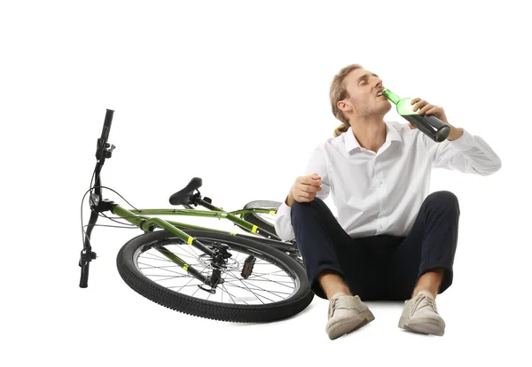 Jeune homme déprimé avec bouteille de vin près du vélo sur fond blanc — Photo