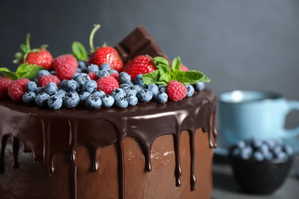 Bolo de chocolate saboroso feito na hora decorado com bagas na mesa, close-up — Fotografia de Stock