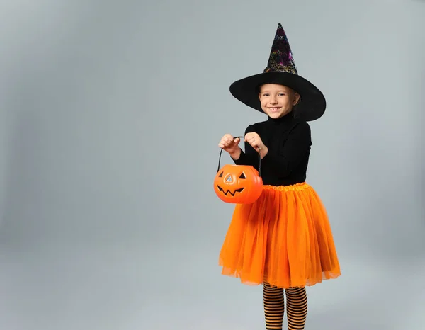 Aranyos kislány tök cukorka vödör visel Halloween jelmez szürke háttér, hely a szöveges — Stock Fotó