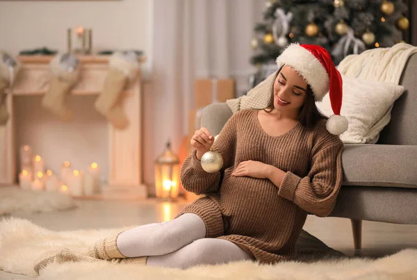 Mulher grávida feliz com bola de Natal em casa. Bebê esperado — Fotografia de Stock