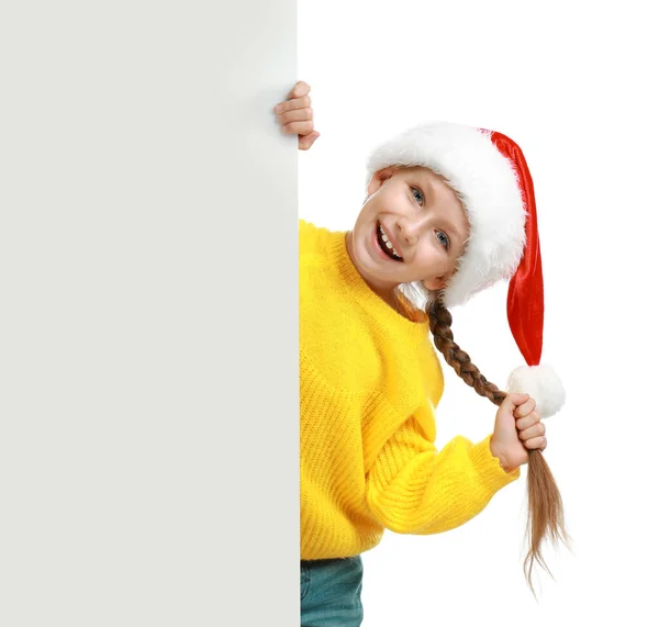 Criança feliz em chapéu de Papai Noel espreitando fora do banner em branco no fundo branco. Celebração de Natal — Fotografia de Stock