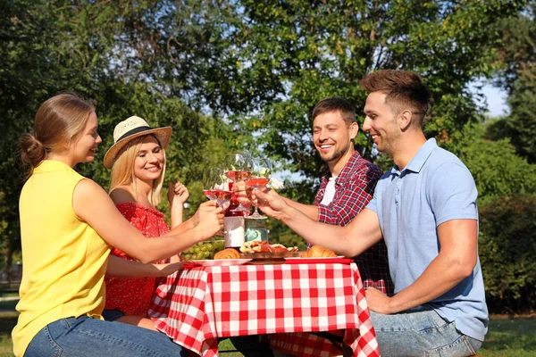 Groep mensen die picknicken aan tafel in Park op zomerdag — Stockfoto