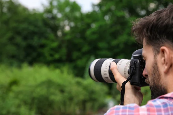 Φωτογράφος λήψη φωτογραφιών με επαγγελματική κάμερα στο πάρκο — Φωτογραφία Αρχείου