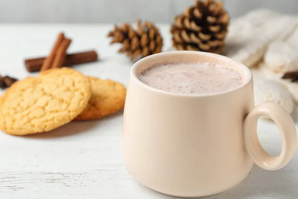 Deliciosa bebida caliente de cacao en taza y galletas en mesa de madera blanca, primer plano —  Fotos de Stock