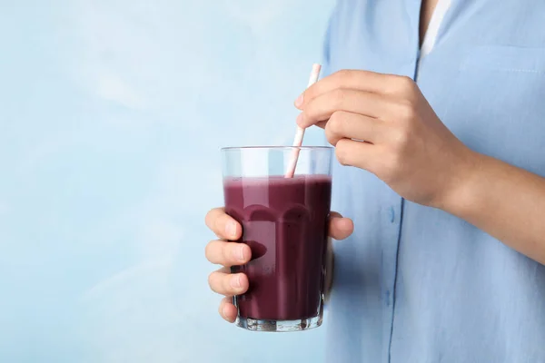 Mujer con vaso de bebida fresca de acai y paja sobre fondo azul claro, primer plano. Espacio para texto —  Fotos de Stock