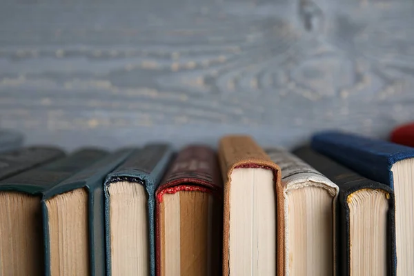 Stapel hardcover boeken op grijze houten ondergrond, close-up. Ruimte voor tekst — Stockfoto