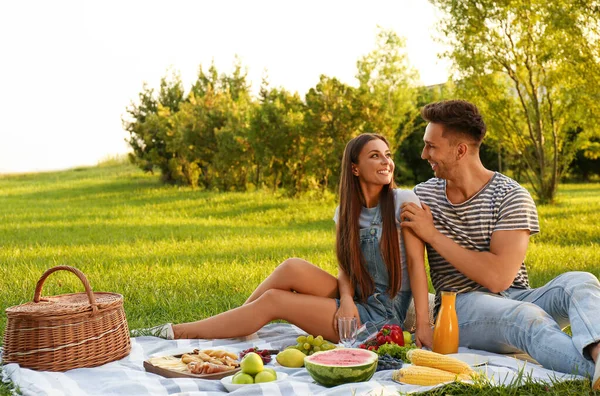 Glückliches Paar picknickt an sonnigem Tag im Park — Stockfoto