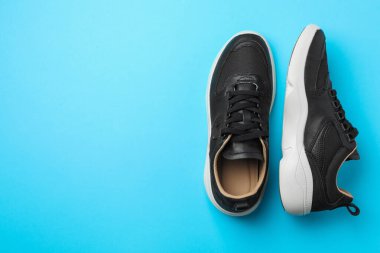 Mavi arka planda bir çift şık ayakkabı, üst manzara. Metin için boşluk