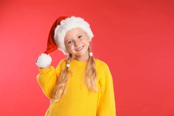 Criança feliz com chapéu de Pai Natal no fundo vermelho. Celebração de Natal — Fotografia de Stock