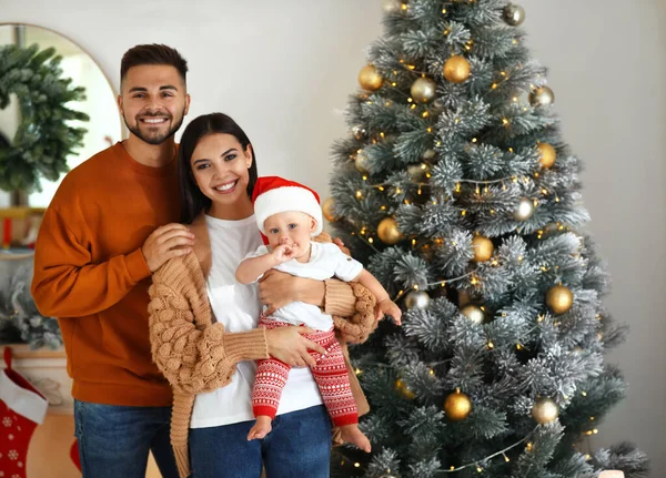 Familia feliz con lindo bebé cerca del árbol de Navidad en casa —  Fotos de Stock