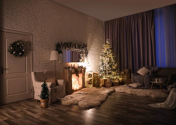 Stijlvol interieur met mooie kerstboom en kunstmatige open haard 's nachts — Stockfoto