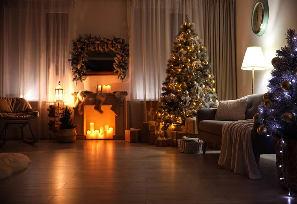 Stilvolles Interieur mit schönem Weihnachtsbaum und dekorativem Kamin in der Nacht — Stockfoto