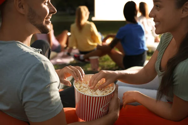 Młoda para z popcornem oglądająca film w kinie na świeżym powietrzu, zbliżenie. Miejsce na tekst — Zdjęcie stockowe