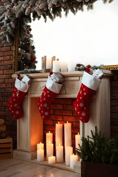 Dekoracyjny kominek z świąteczną pończochą i prezentami w stylowym wnętrzu pokoju — Zdjęcie stockowe