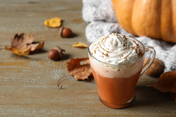 Kürbis-Gewürz-Latte mit Schlagsahne im Glasbecher auf Holztisch. Raum für Text — Stockfoto