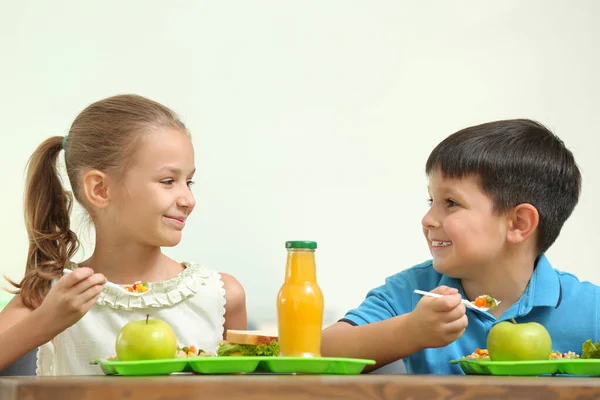 Happy children eating healthy food for lunch in school canteen Stock Image