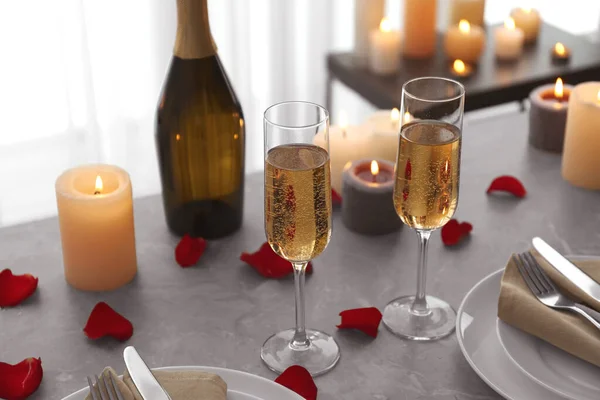 Romantische Tischdekoration mit brennenden Kerzen und Rosenblättern drinnen — Stockfoto