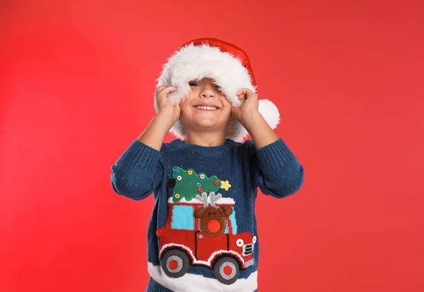 Criança feliz com chapéu de Pai Natal no fundo vermelho. Celebração de Natal — Fotografia de Stock