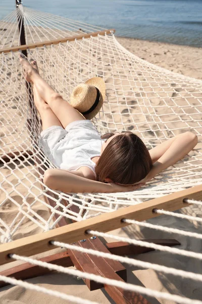 Giovane donna rilassante in amaca sulla spiaggia — Foto Stock