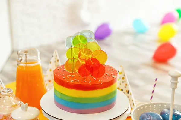 Pastel de cumpleaños brillante y otras golosinas en la mesa en la habitación decorada — Foto de Stock