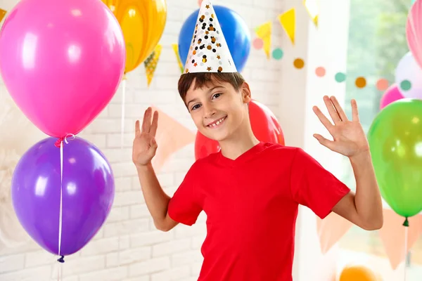 Happy boy near bright balloons at birthday party indoors — ストック写真