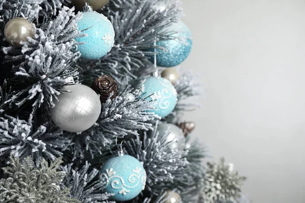 Όμορφο χριστουγεννιάτικο δέντρο με διακόσμηση σε ανοιχτό γκρι φόντο, closeup. Χώρος για κείμενο — Φωτογραφία Αρχείου