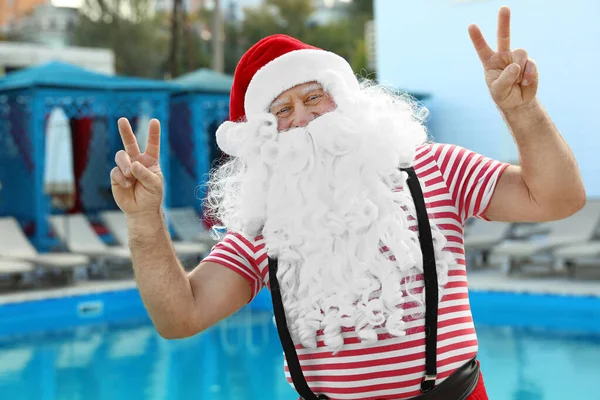 Authentic Santa Claus having fun near pool at resort — ストック写真