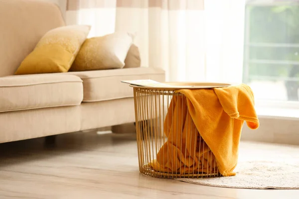 Металлическая корзина с желтым одеялом в современном помещении, место для текста. Идея для дизайна интерьера — стоковое фото