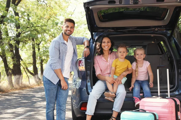 Glückliche Familie in der Nähe des Kofferraums am sonnigen Tag. Roadtrip — Stockfoto