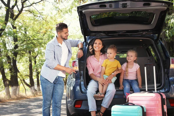 Famiglia felice vicino al bagagliaio dell'auto nella giornata di sole. Viaggio in macchina — Foto Stock