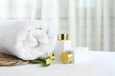 Beyaz havlu üzerine kozmetik ürünler içeren kompozisyon, yazı için boşluk. Spa terapisi