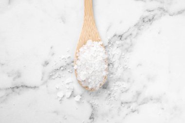Mermer masada beyaz deniz tuzu olan kaşık, üst manzara. Spa tedavisi