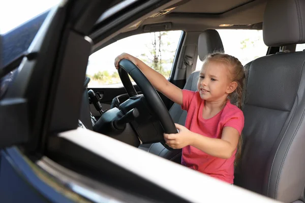 Petite fille jouant avec le volant dans la voiture. Voyage en famille — Photo