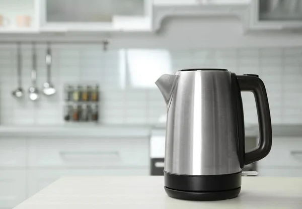 Modern electric kettle on wooden table in kitchen. Space for text — Stock Photo, Image