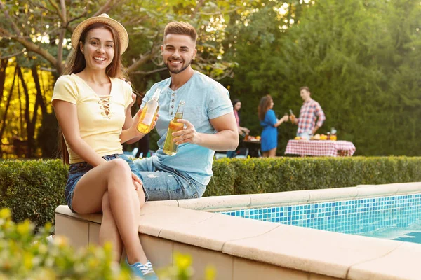 Amici felici con bevande alla festa barbecue vicino alla piscina all'aperto — Foto Stock
