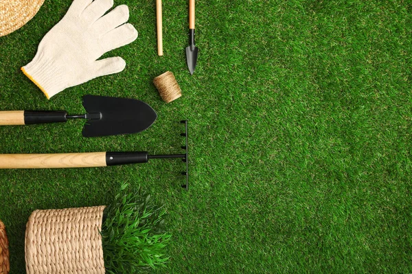 Conjunto de herramientas de jardinería en la hierba verde, la puesta plana. Espacio para texto — Foto de Stock