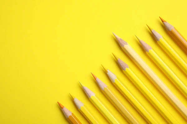 Composição de leigos planos com lápis de cor no fundo amarelo, espaço para texto — Fotografia de Stock