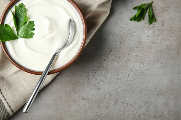 Flat lay composition with sour cream and parsley on grey table, space for text — Stock Photo, Image