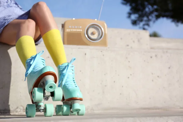 Jonge vrouw met vintage rolschaatsen en radio zittend op stenen trap, close-up zicht — Stockfoto