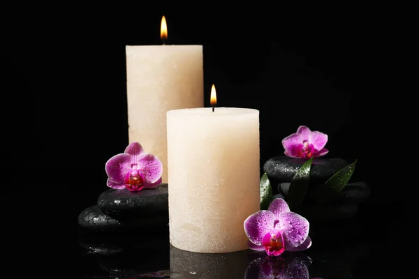 Composição com velas e pedras de spa sobre fundo preto — Fotografia de Stock