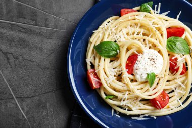 Gri masadaki ekşi krema soslu lezzetli spagetti.