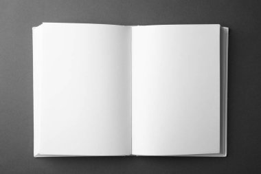 Koyu gri arkaplan üzerine boş sayfaları olan açık bir kitap, üst görünüm. Tasarım için hazırlan