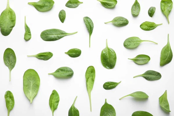 Fresh green healthy spinach leaves with water drops on white background, top view — Stock Photo, Image