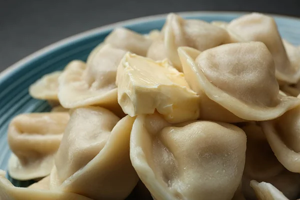 Smakliga dumplings med smör på blå tallrik, närbild — Stockfoto