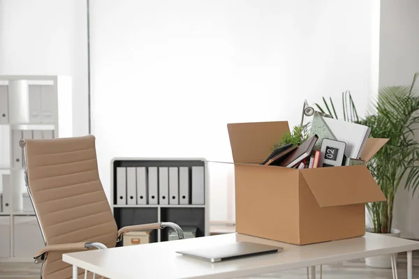 Cardboard box full of stuff on table in office — Stock Photo, Image
