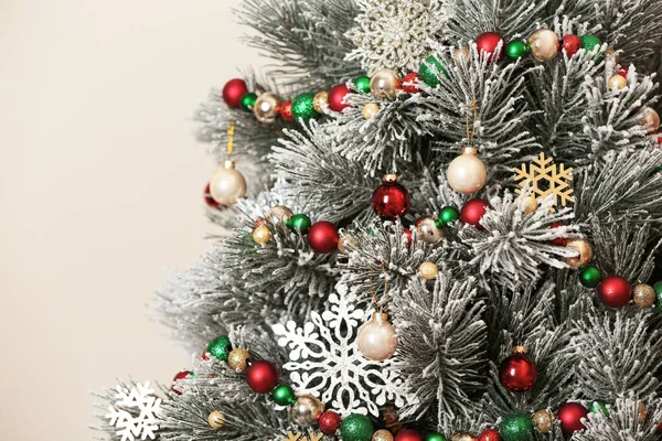 Mooie kerstboom met decor tegen lichte achtergrond, close-up — Stockfoto